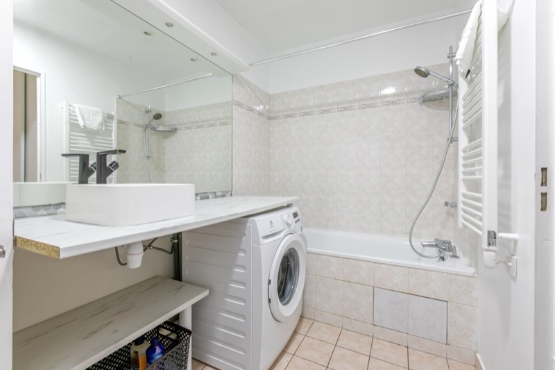 Badezimmer mit Badewanne und Waschmaschine